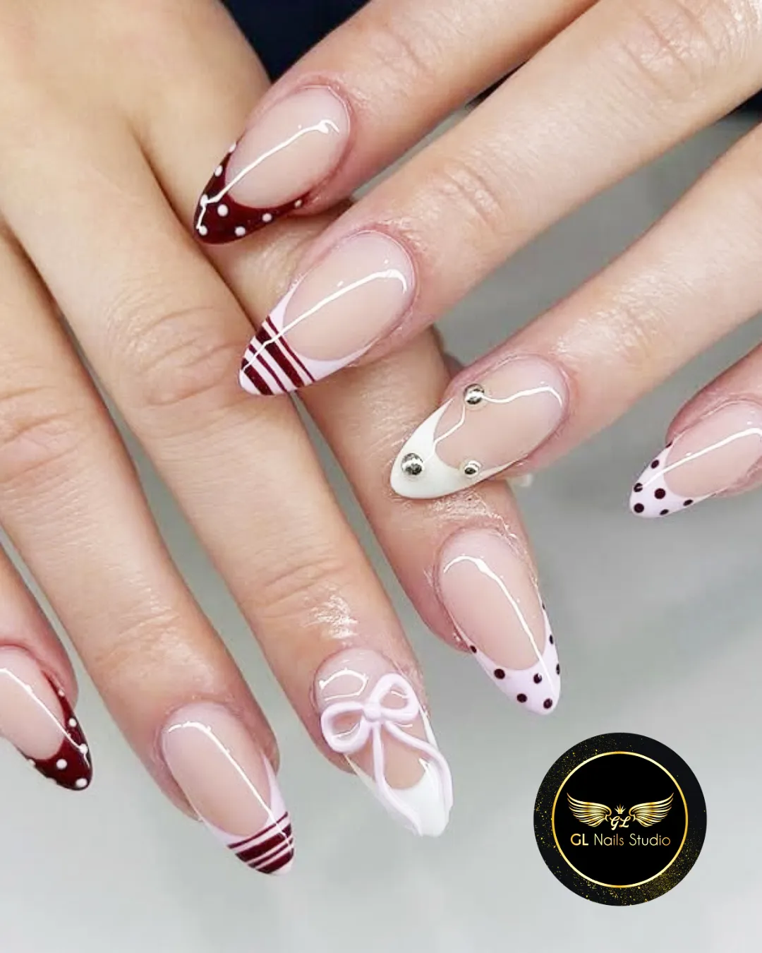 Mixed French tips: burgundy polka dots, stripes, and bow