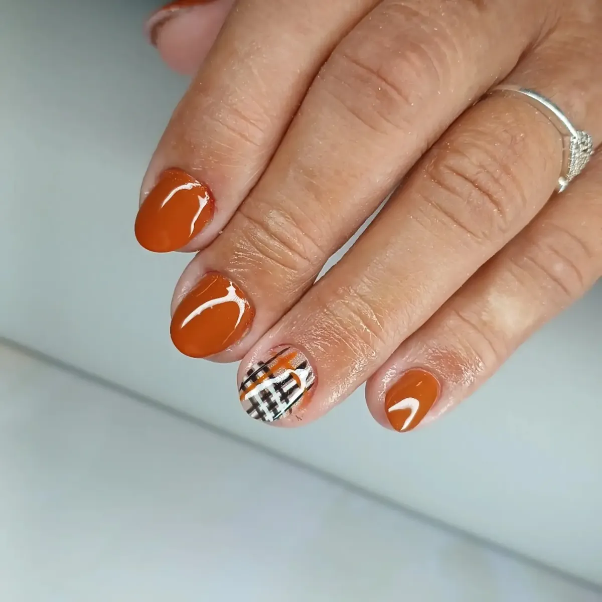 Glossy burnt orange with plaid accent nail