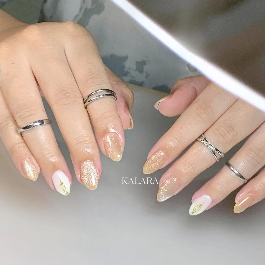 Gold-glitter set with milky white accent nails and gold motif