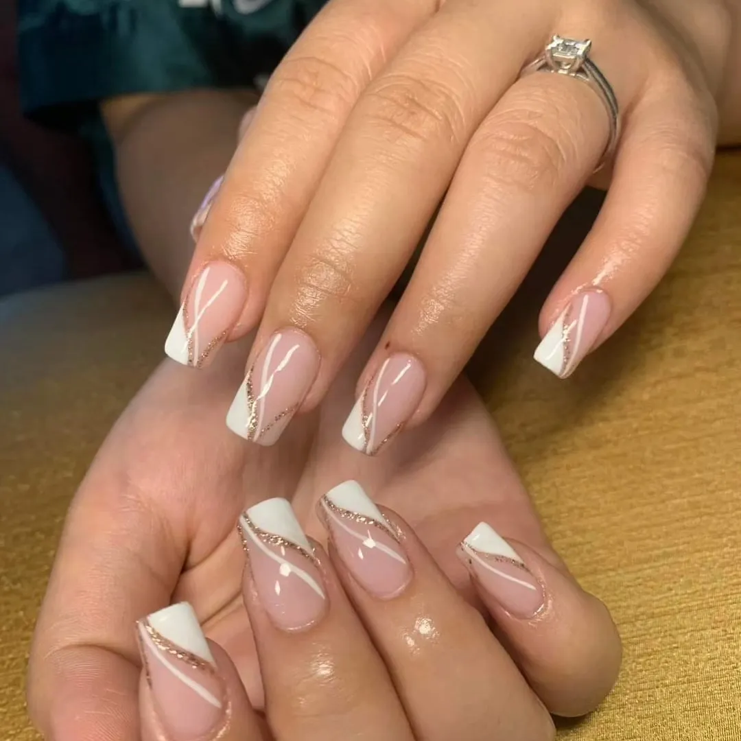 Square nude nails with angled white tips and glitter striping