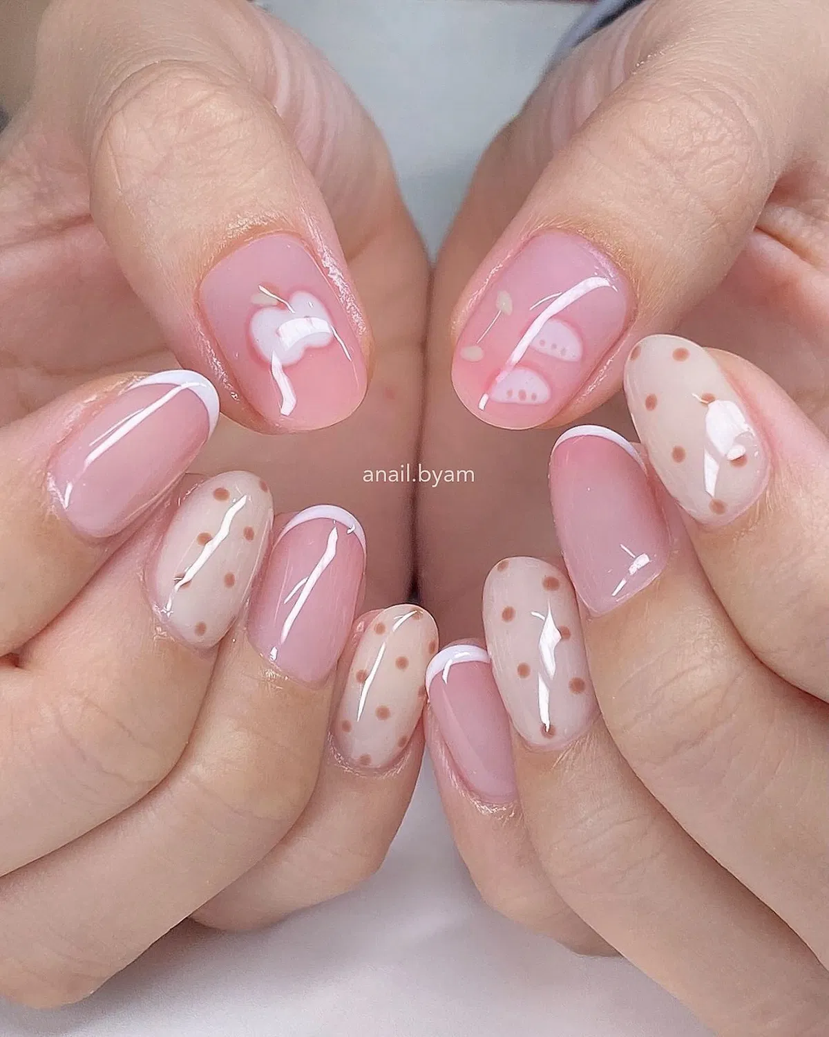 Soft pink nails with tan polka dots and white linework