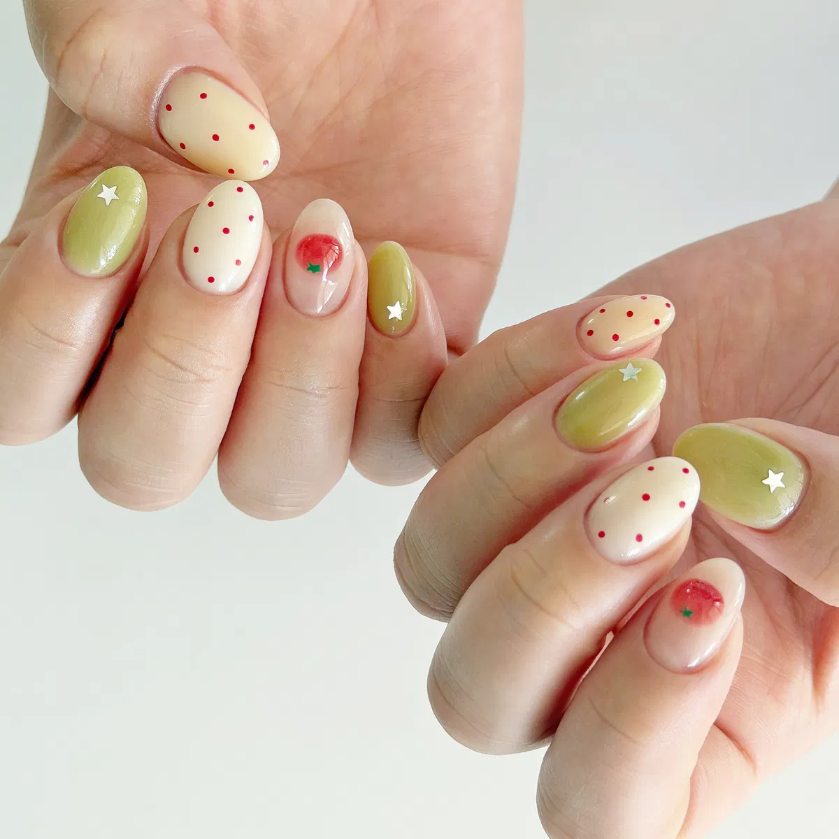 Cream-and-olive nails with tiny red polka dots