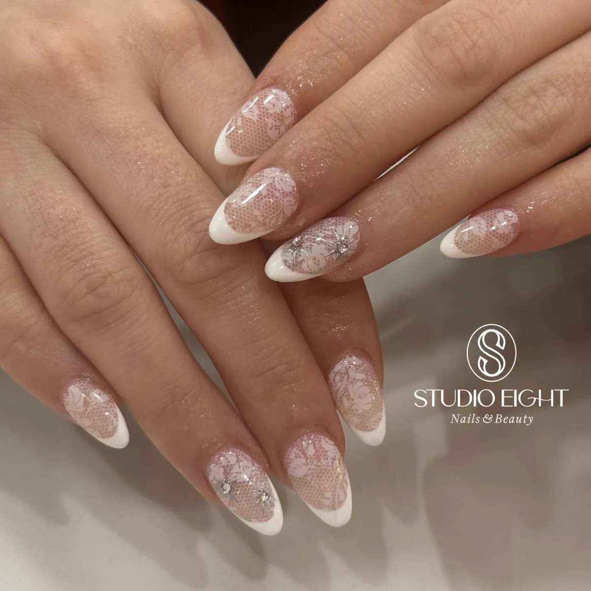 Lace-overlay French tips with small rhinestones