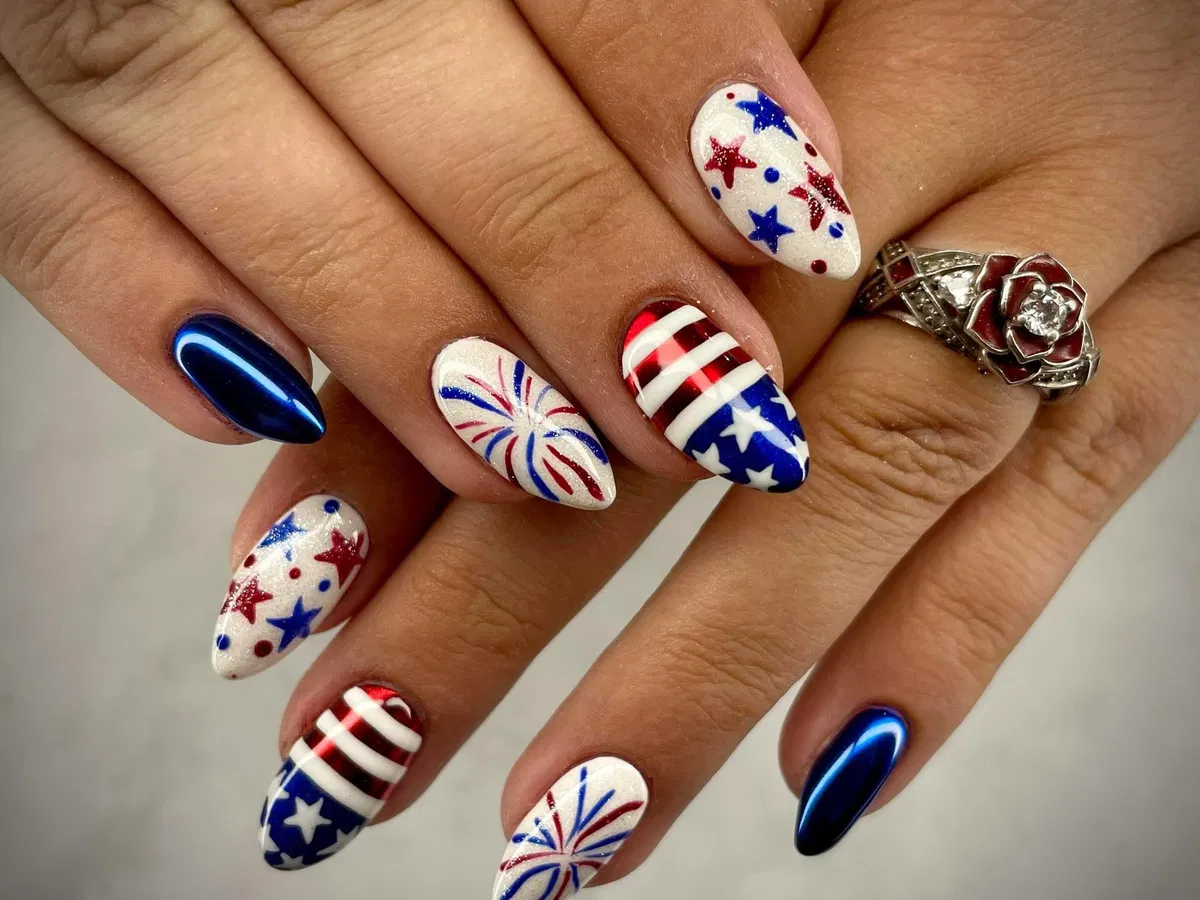 Almond nails with stars, stripes, bursts, and metallic blue solids