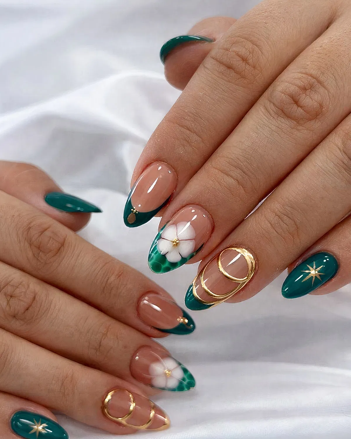 Teal French tips with gold outlines and white floral accents