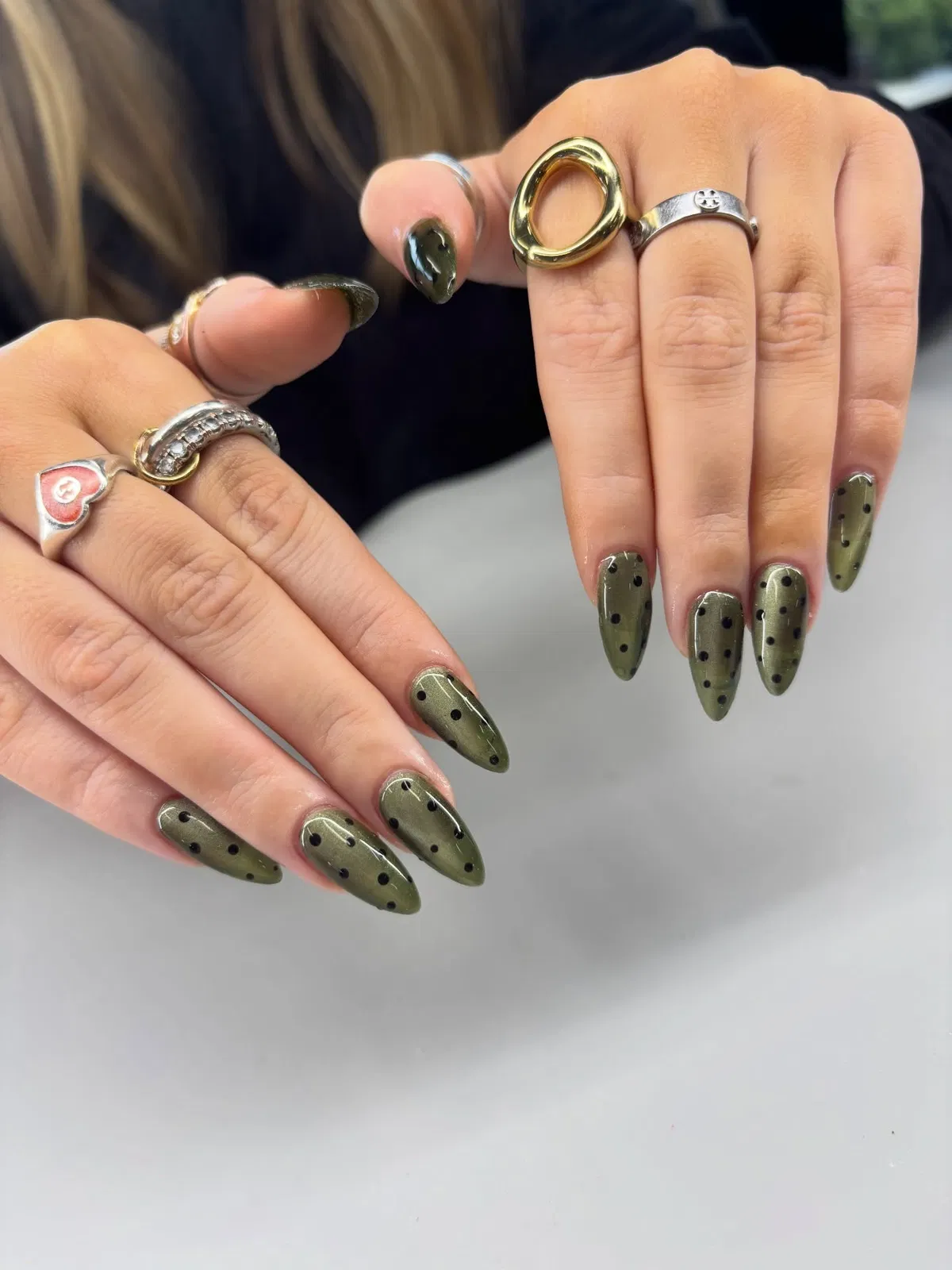 Olive green stiletto nails with black polka dots
