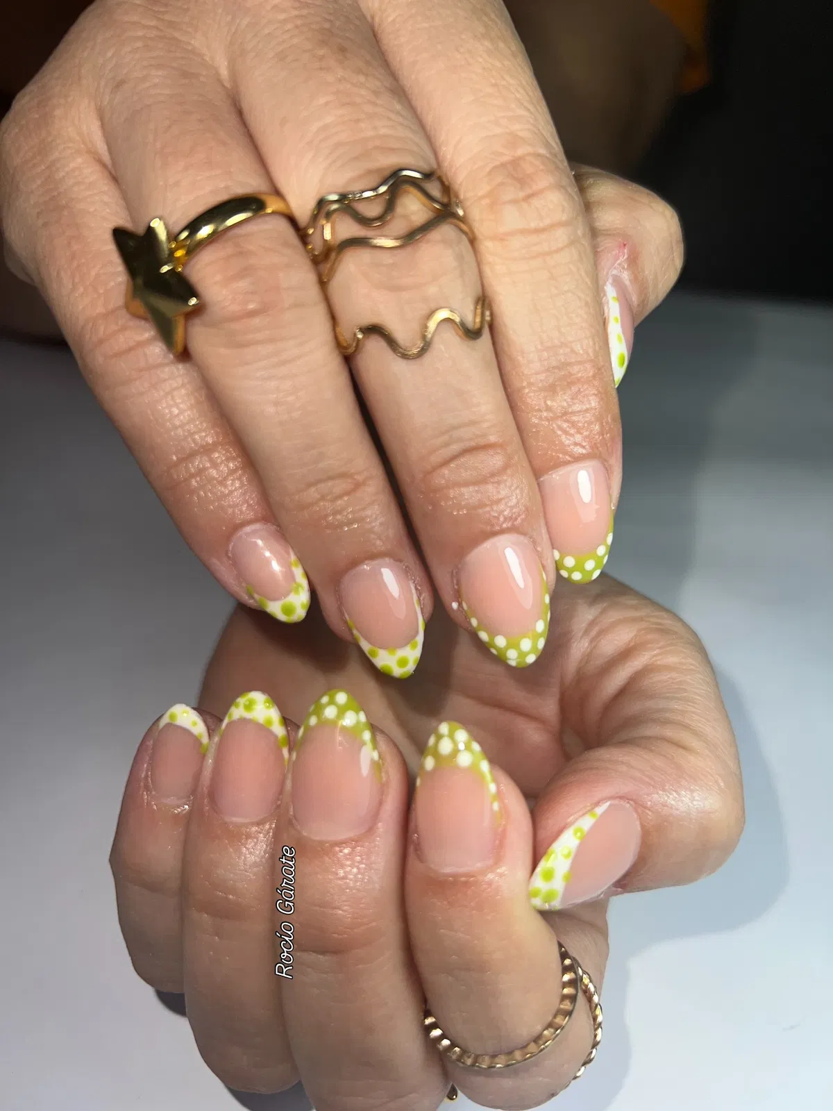 Glossy green polka-dot French tips with diagonal accent