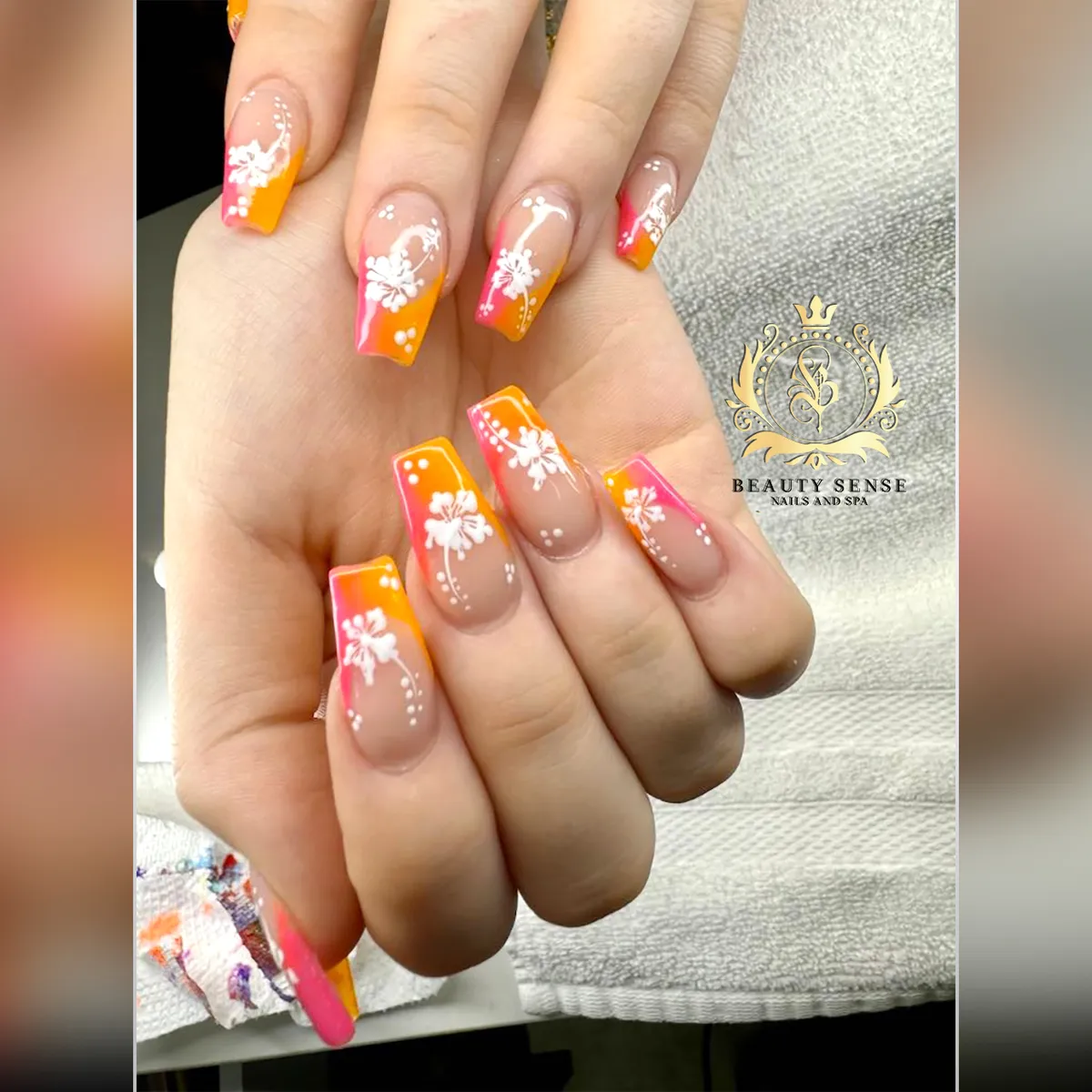 Orange-to-pink gradient tips with white florals