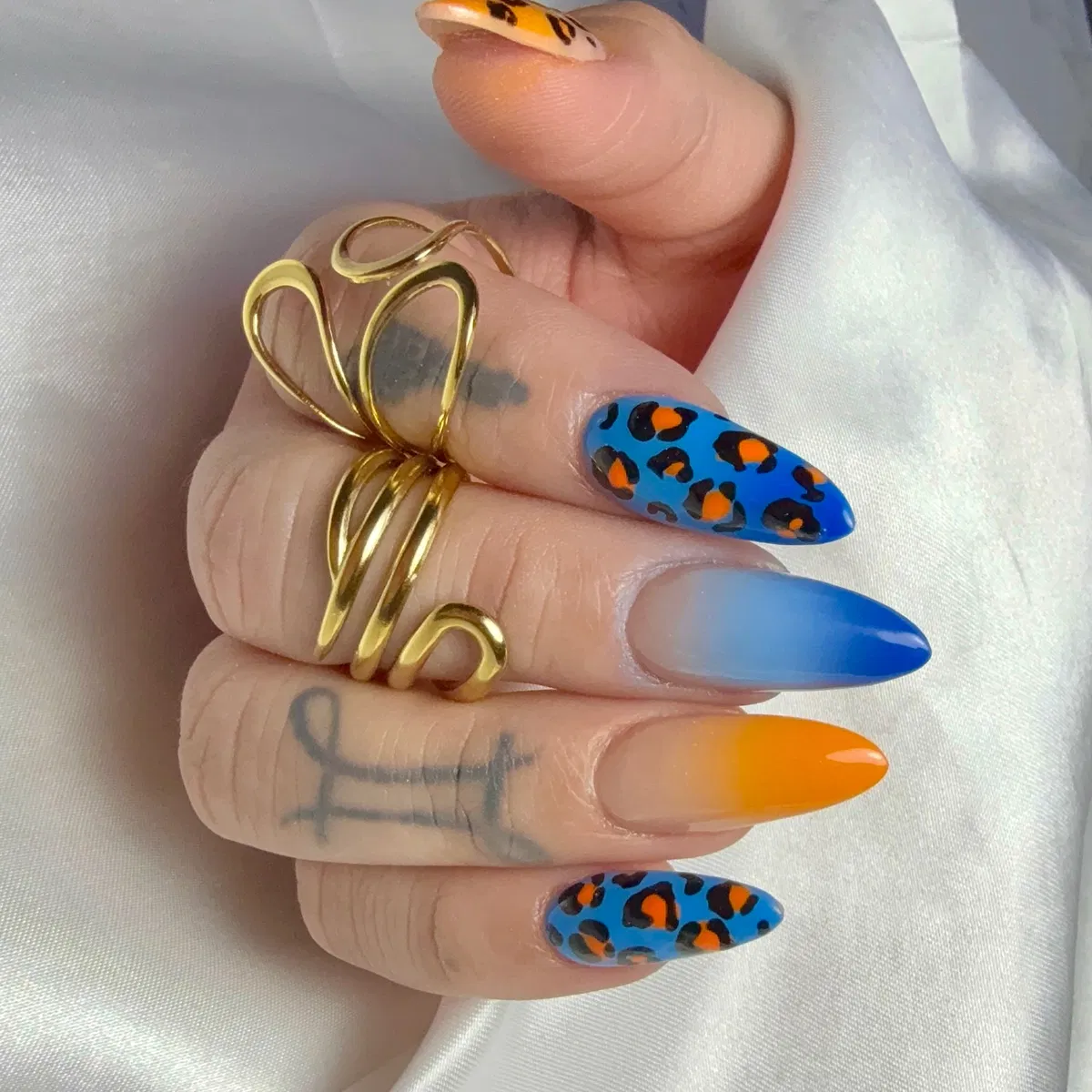 Blue leopard spots with orange centers and blue/orange ombrรฉ tips