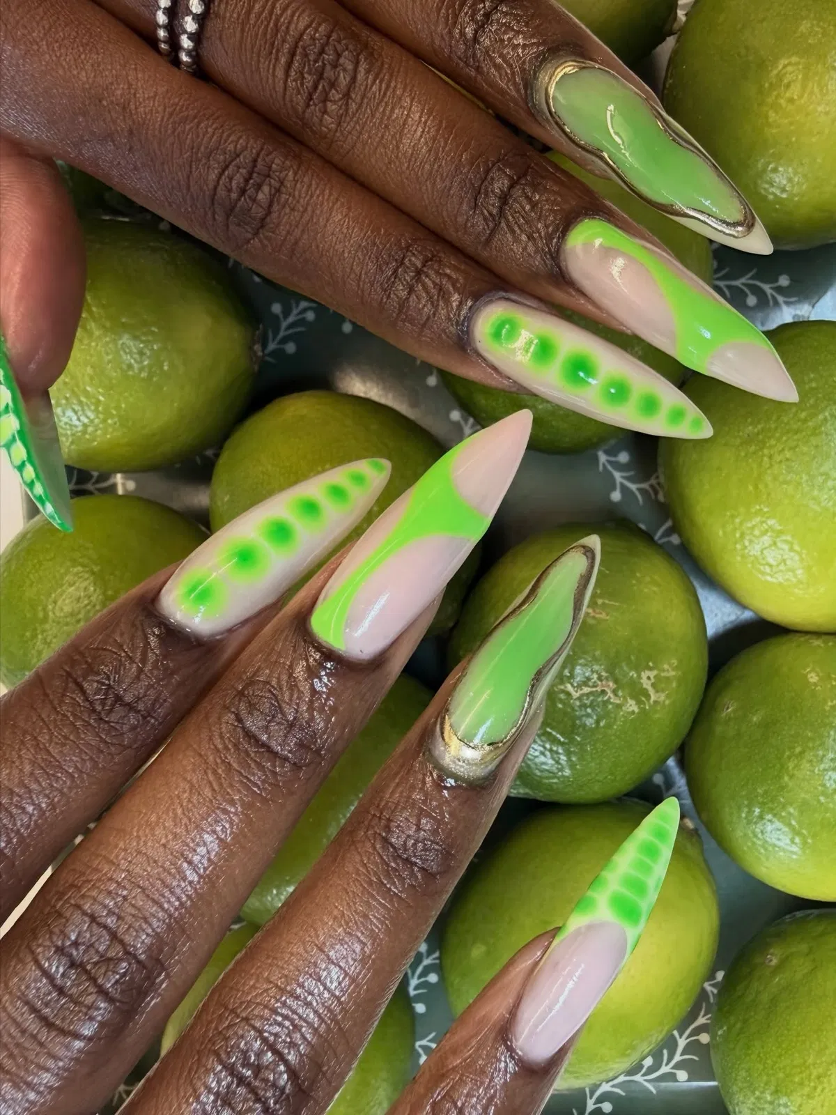 Stiletto lime tips with dotted accents and gold outlines