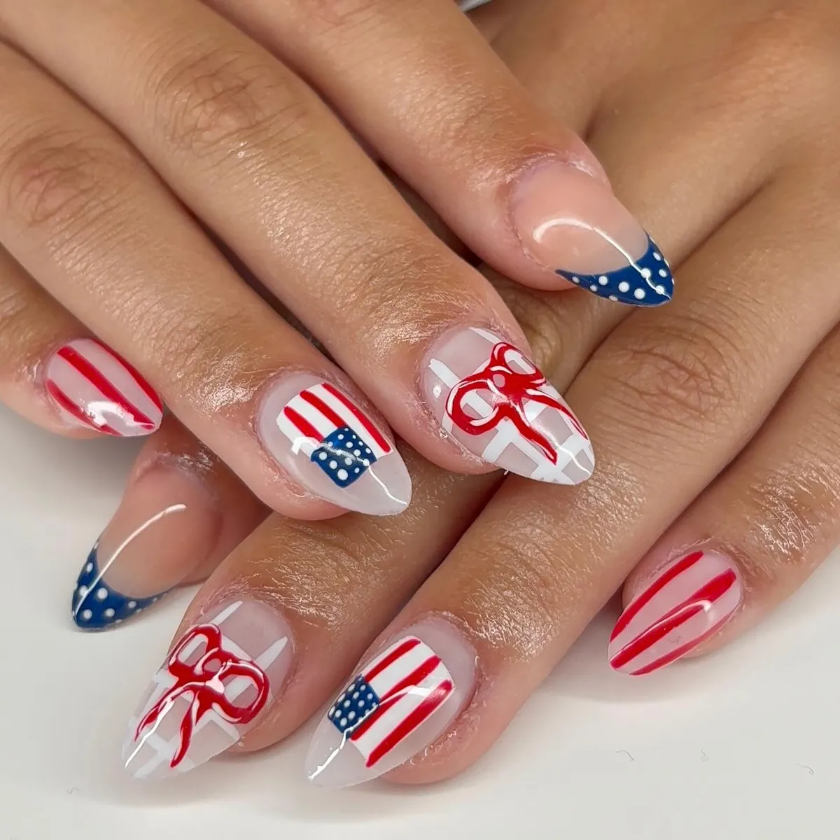 Polka-dot French tips, stripes, and red bow accents