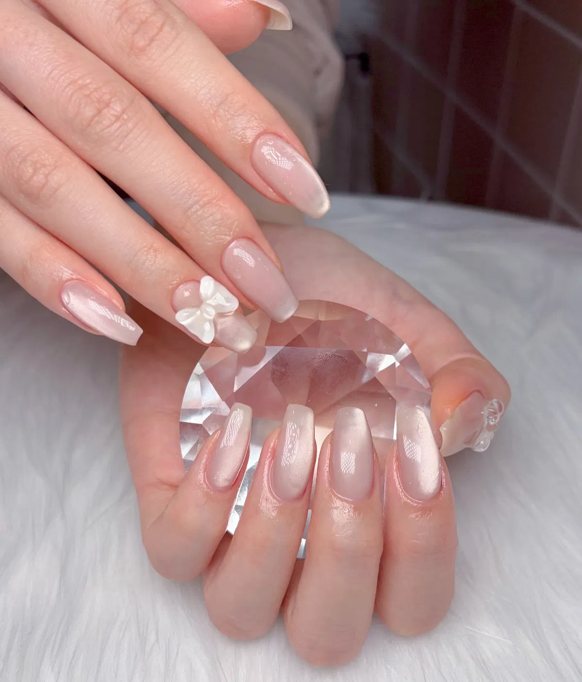 Pearly nude square nails with a single 3D flower accent