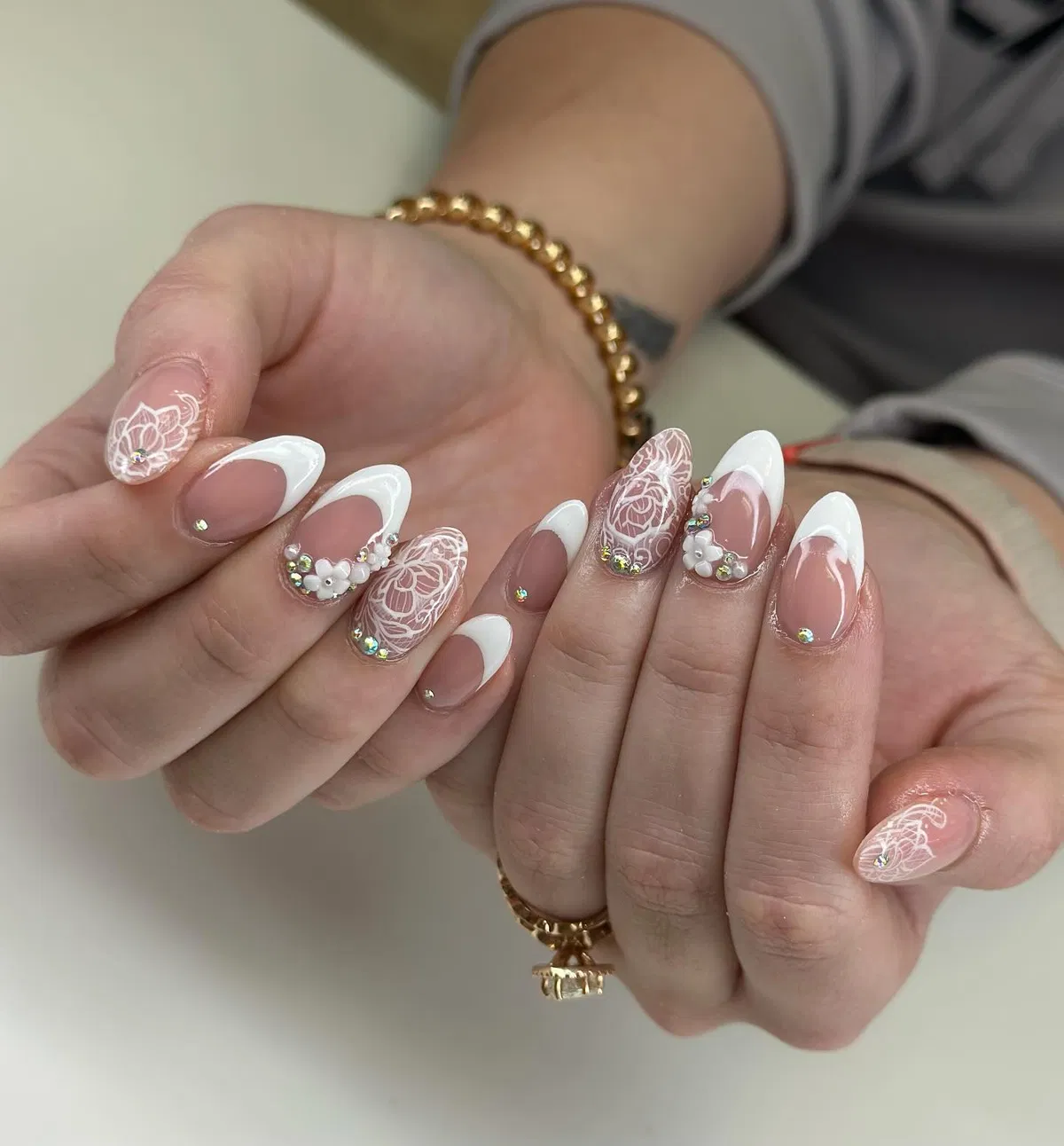 White French tips with lace-style florals and rhinestones
