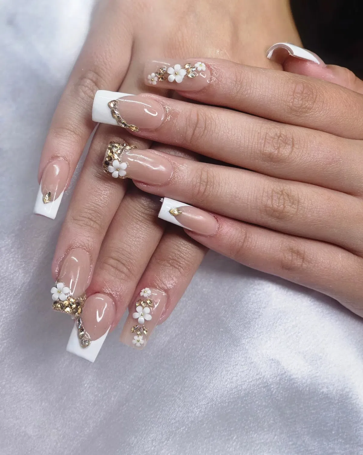Square French tips with gold embellishments and small 3D florals