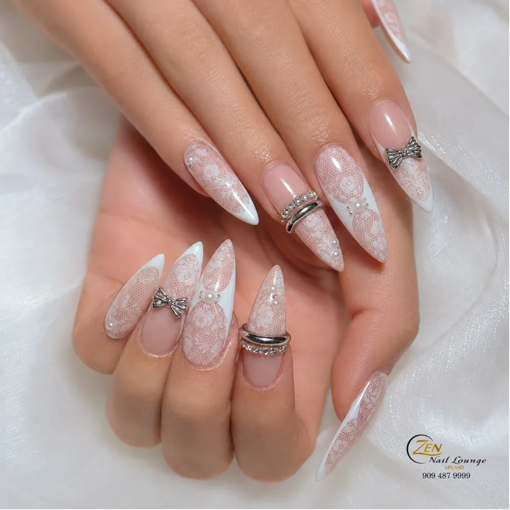 Stiletto lace-pattern tips with pearl accents and silver bow charms