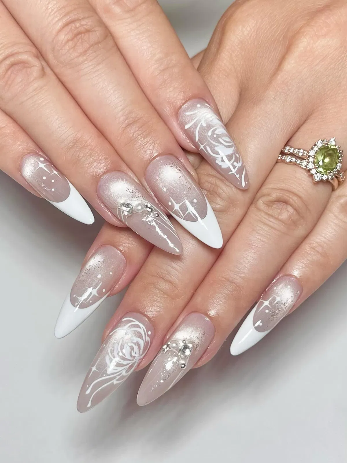 Pointed French tips with white roses and sparkle motifs