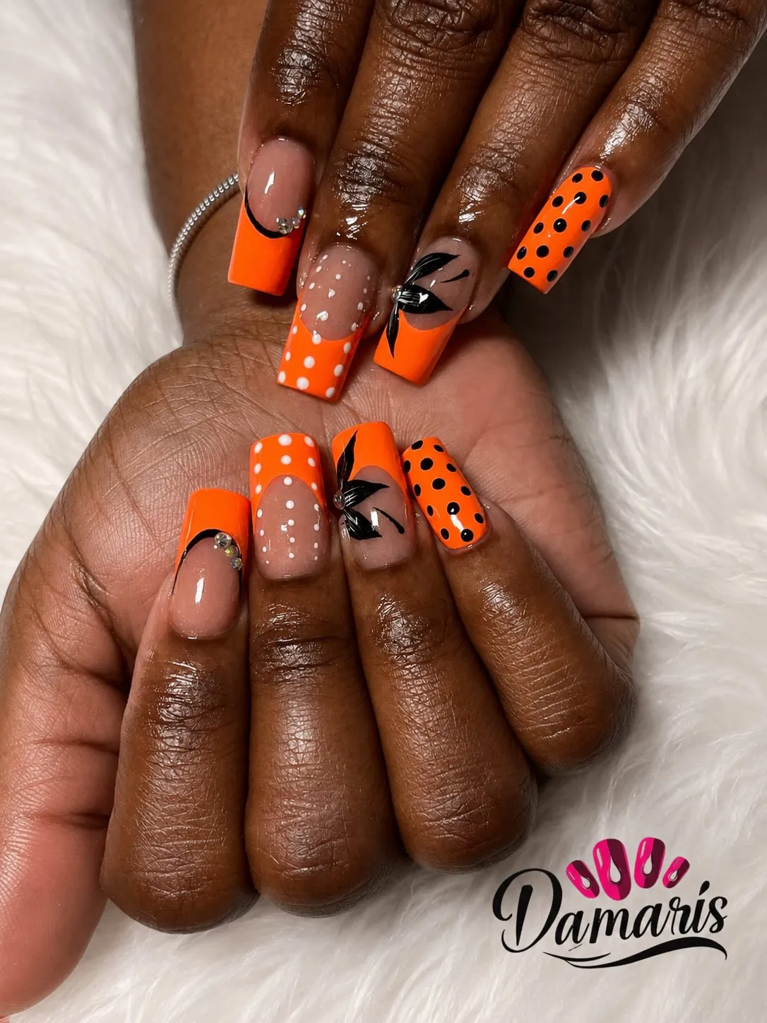 Square orange French tips with dots, bow art, and rhinestones