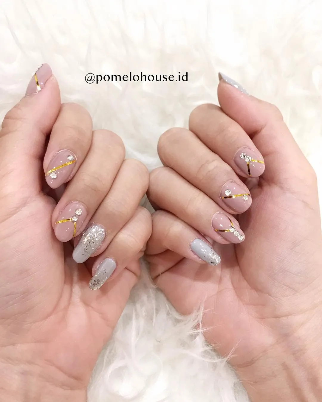 Nude nails with gold striping and silver glitter accents