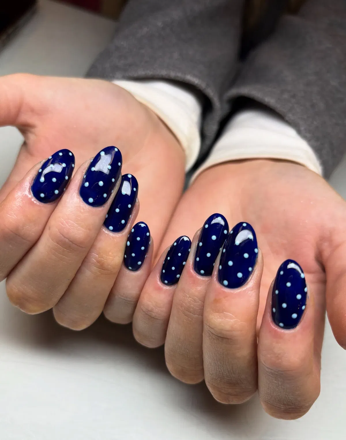 Navy oval nails with light blue dots and star accents