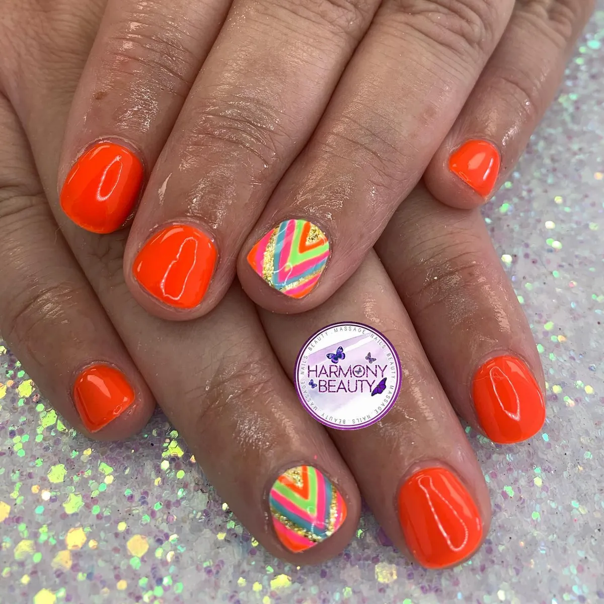Glossy neon orange with multicolor chevron accent nails
