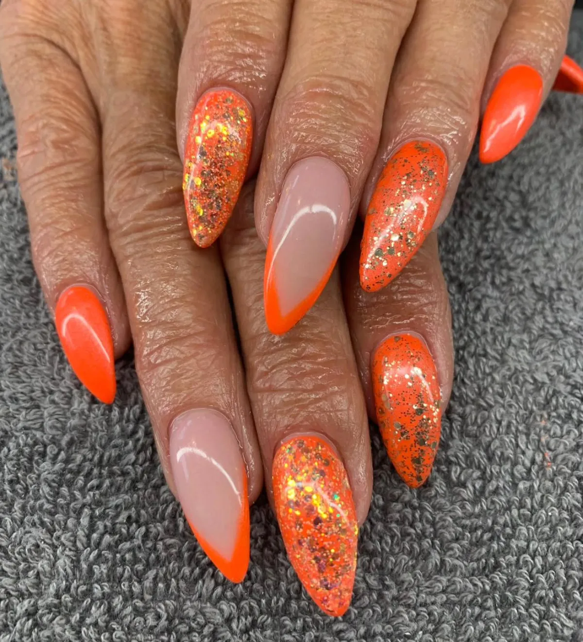 Neon orange French tips with speckled accents