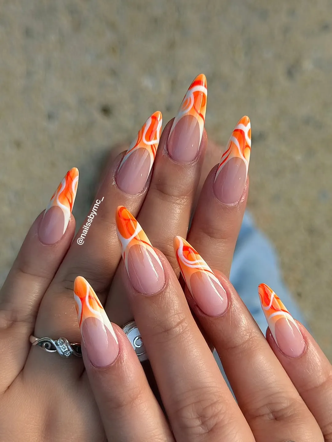 Orange-and-white swirl French tips on long stilettos