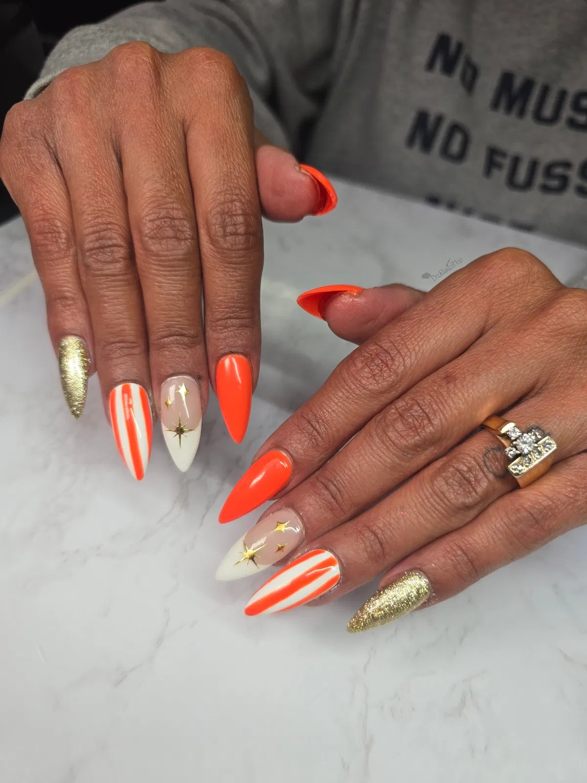 Neon orange with stripes, gold glitter, and star studs