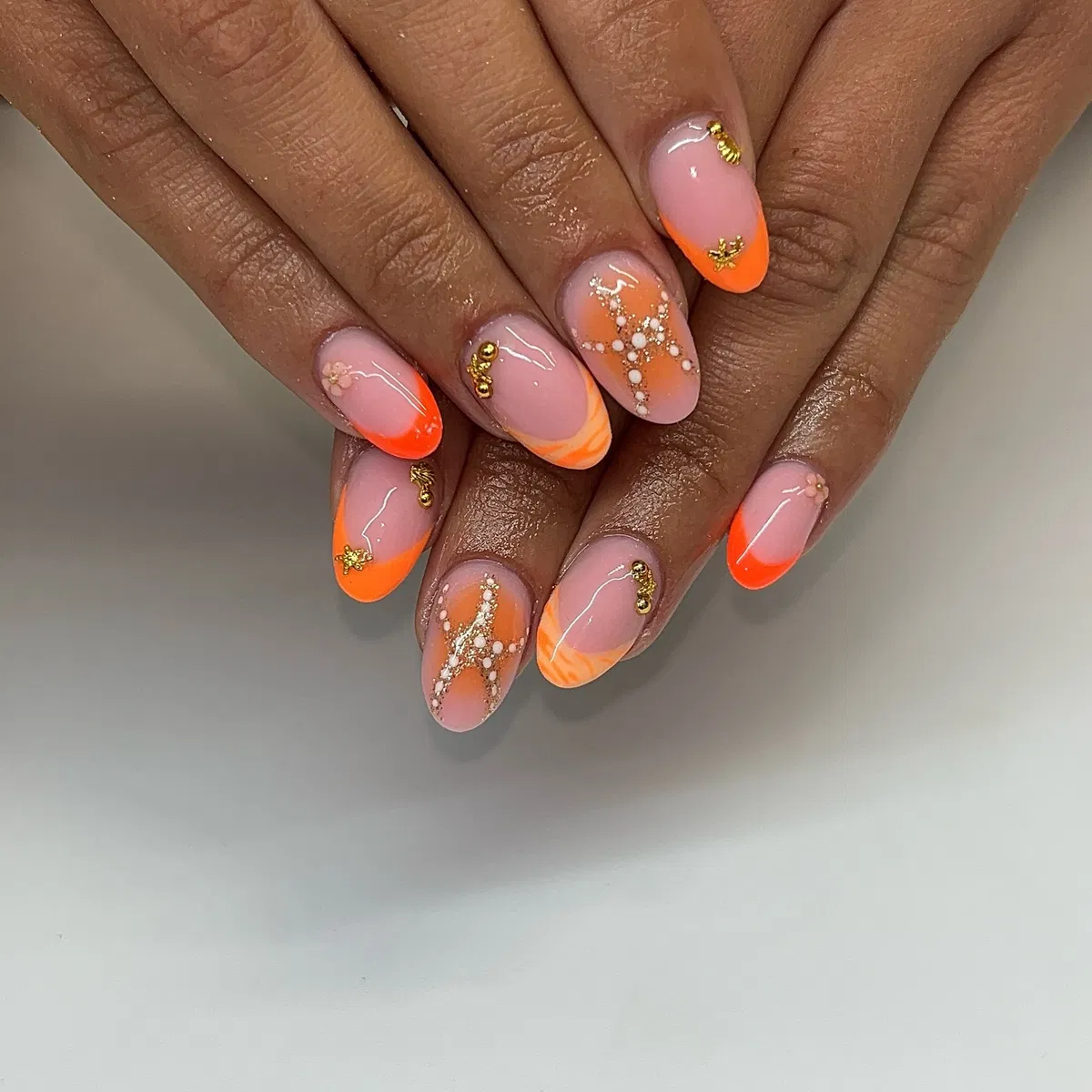 Orange ombrรฉ French with gold charms