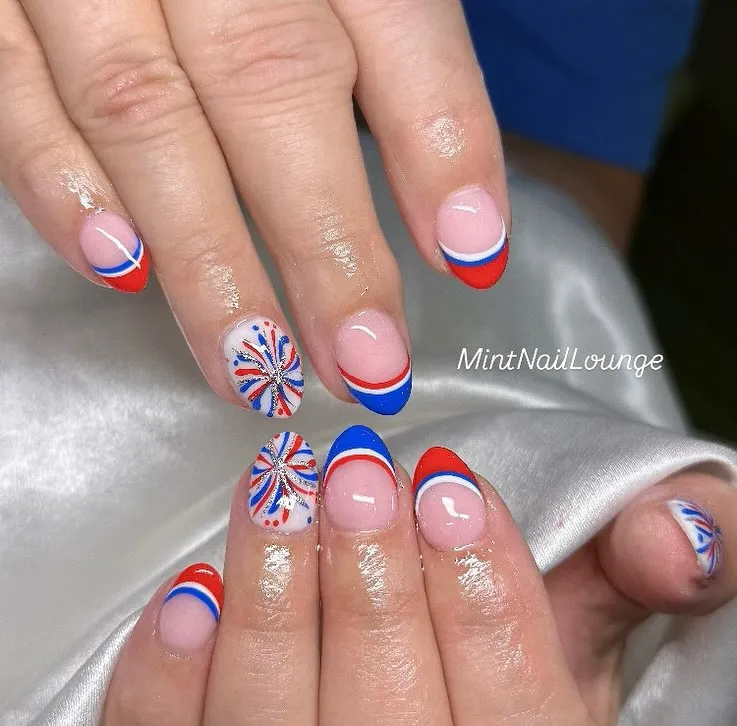 Coordinated red/blue French tips with burst-pattern accent nails