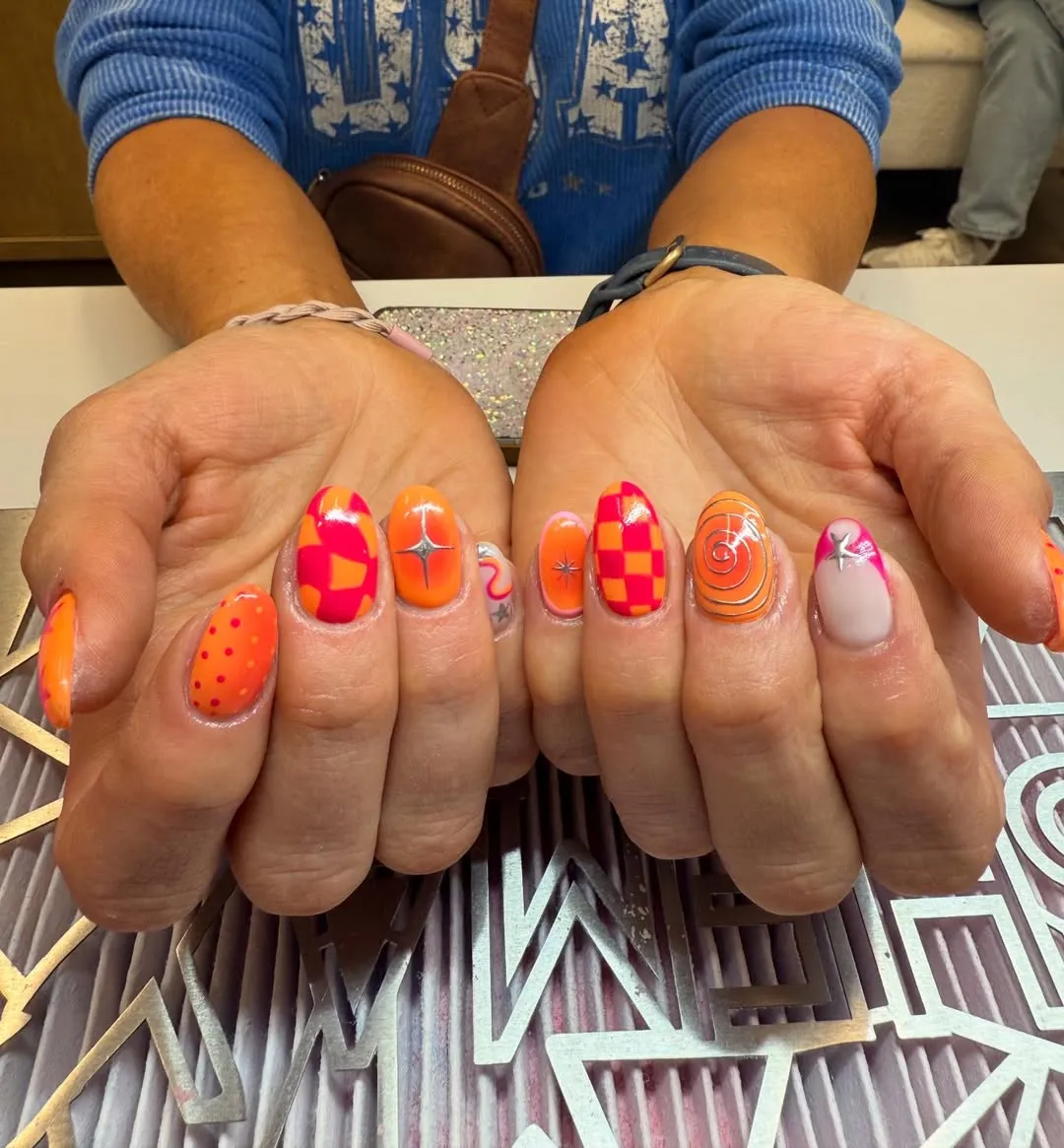Checkerboard and spiral pink-orange nails with star charms