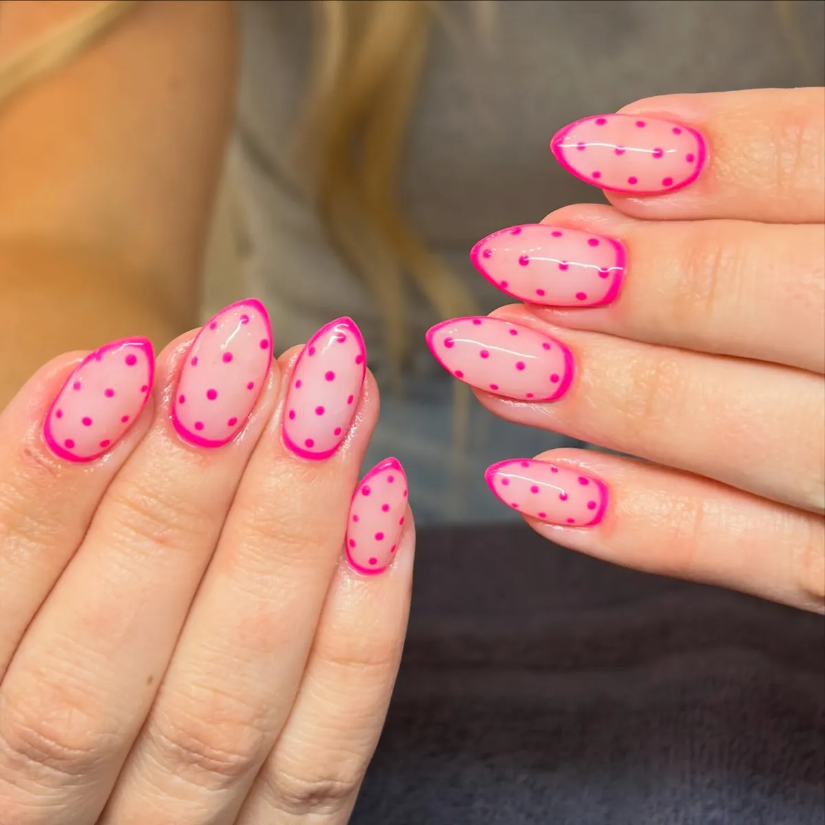 Outlined nude-pink nails with bright pink polka dots
