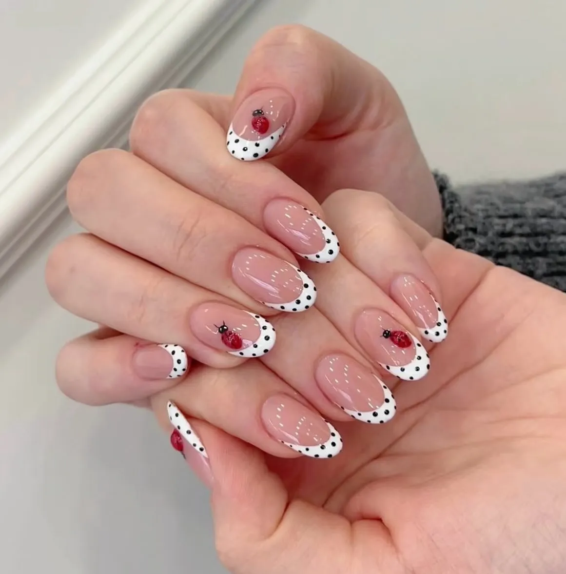 Classic black polka-dot French tips with ladybug accents