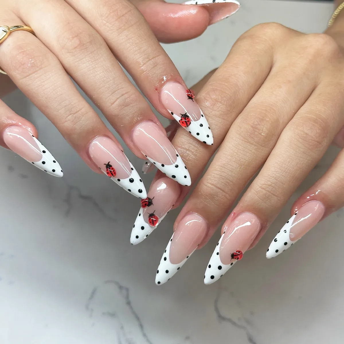 Stiletto polka-dot French tips with ladybug art