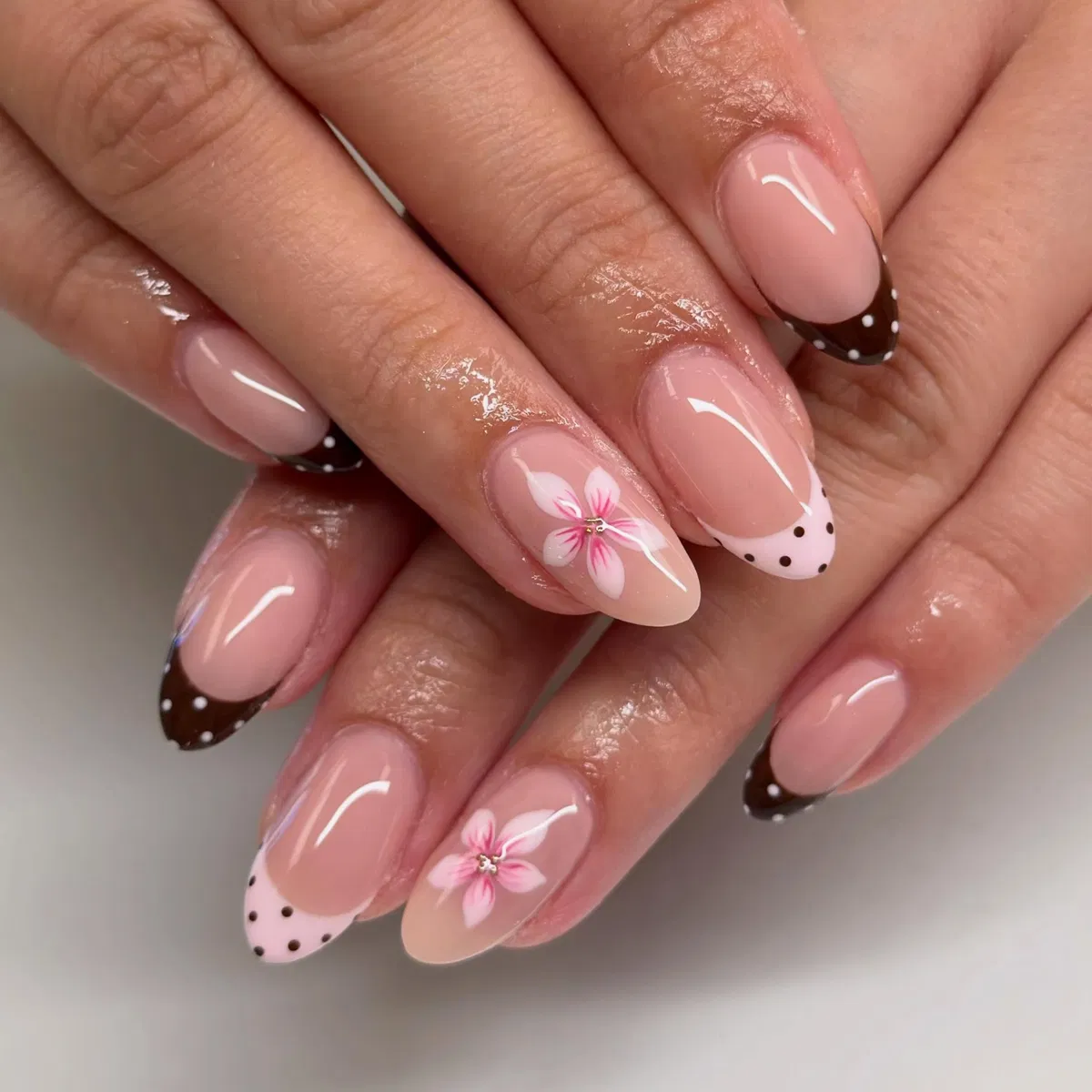 Brown polka-dot French tips with pink floral accents