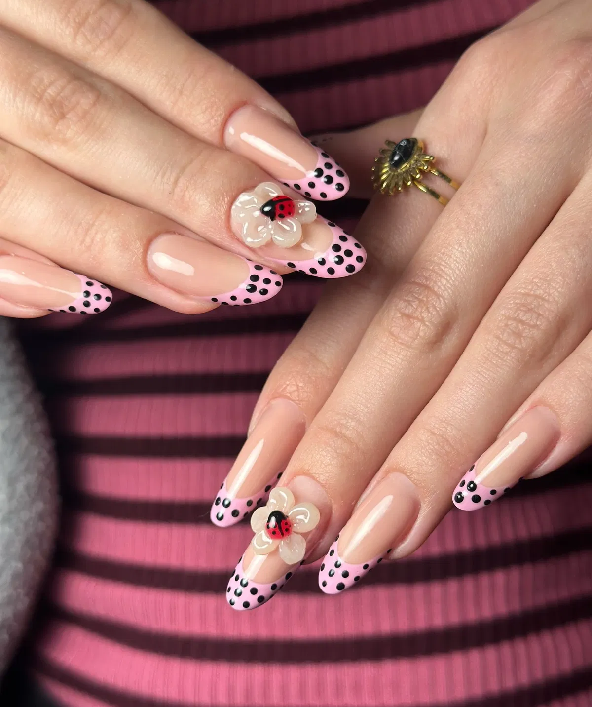 Pink polka-dot French tips with 3D flower and ladybug accent