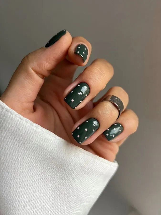 Dark green short nails with pale pink polka dots