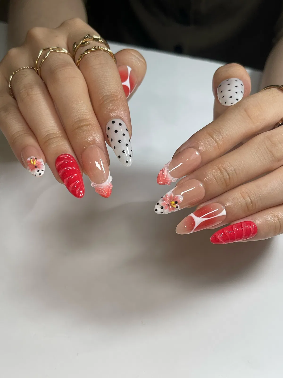 Mixed red accents with a single polka-dot feature nail