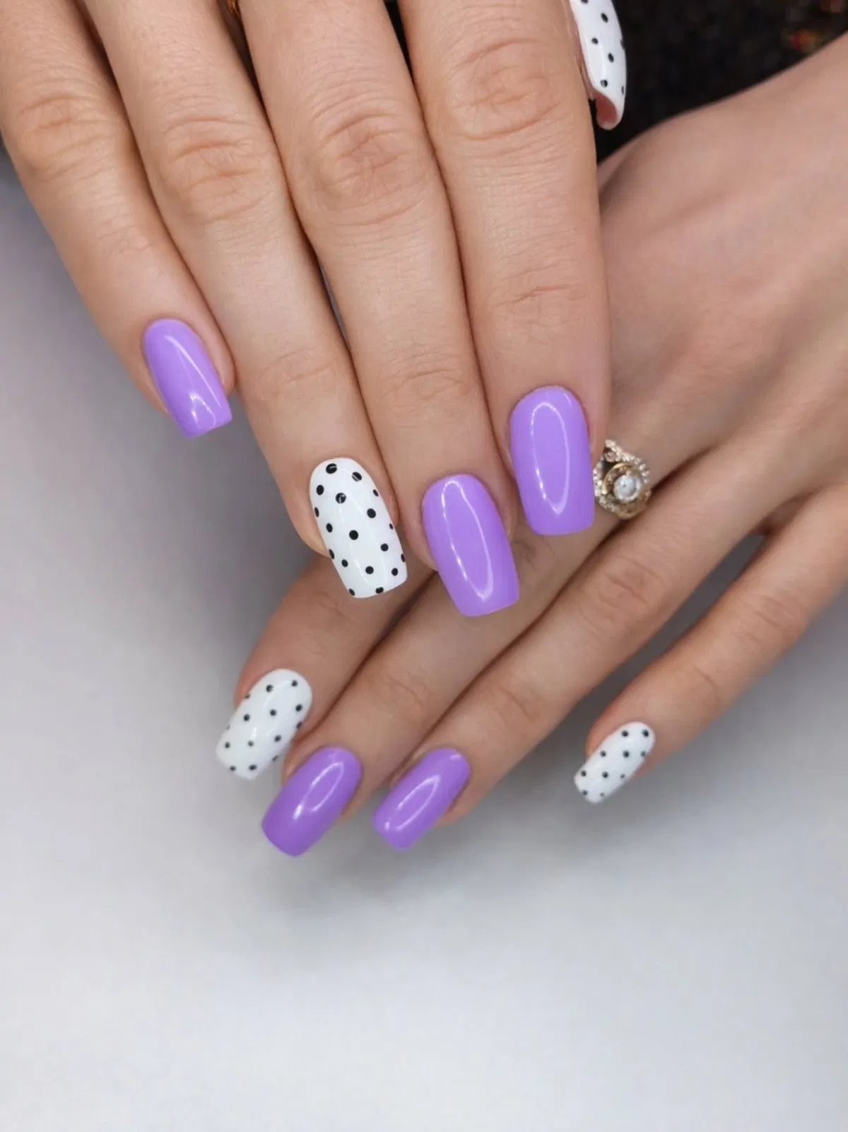 Glossy purple squares with white-and-black polka-dot accent nails