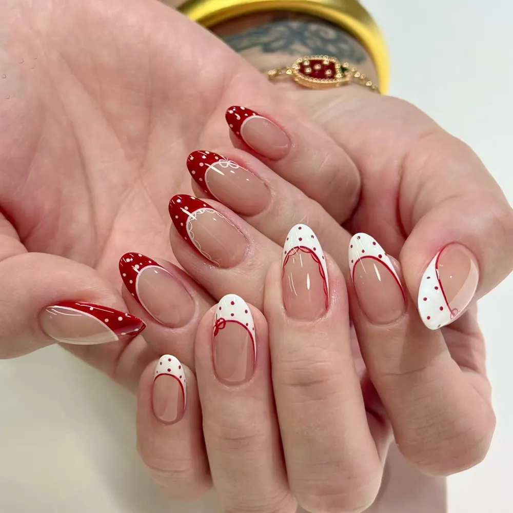 Curved red-and-white French tips with mixed polka dots
