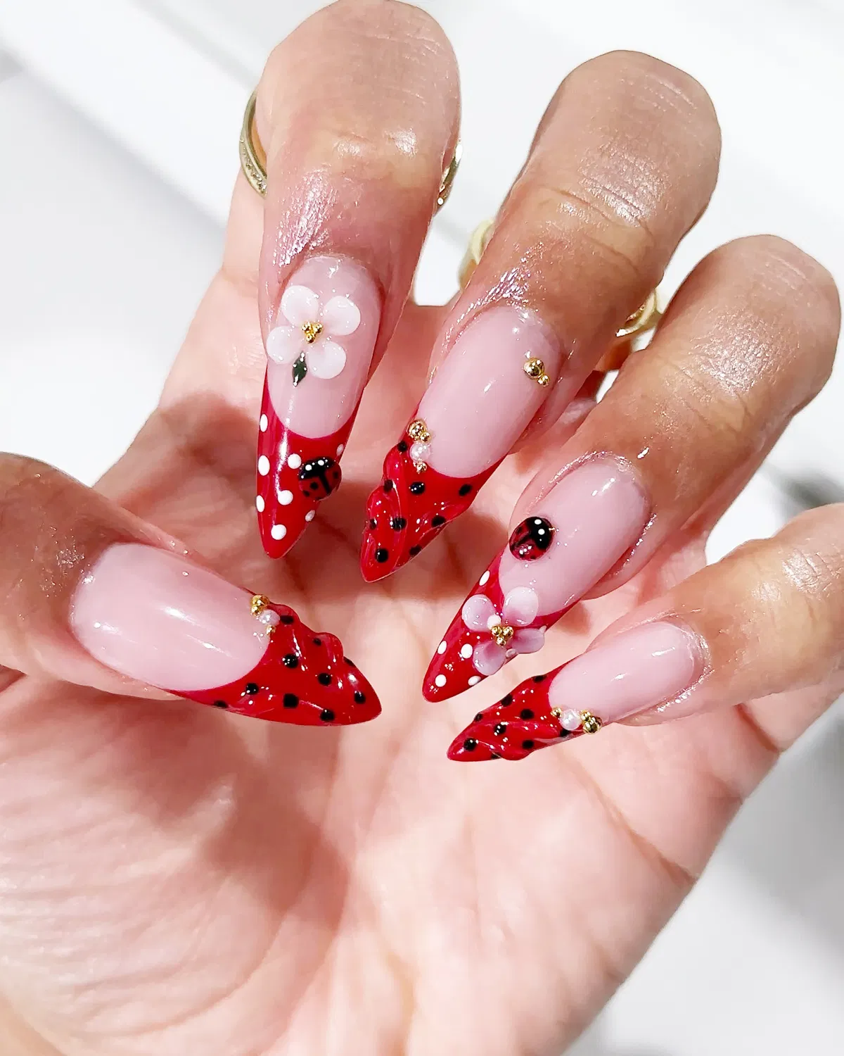 Stiletto red polka-dot tips with 3D flowers and ladybug accents