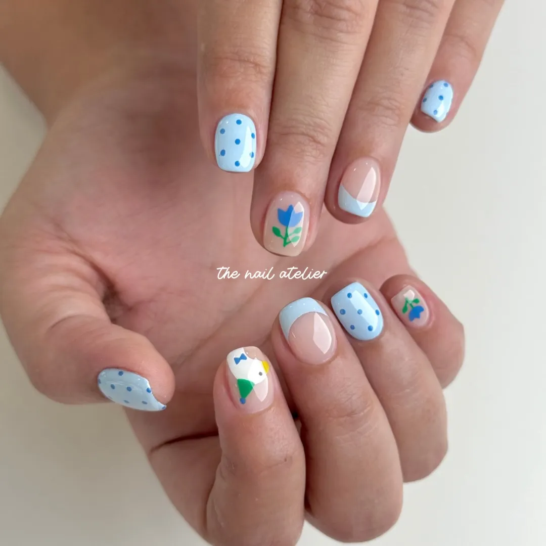 Blue polka dots mixed with nude French tips and floral accents
