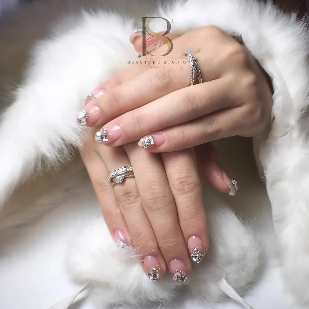 Pale pink glossy nails with clustered crystal accents