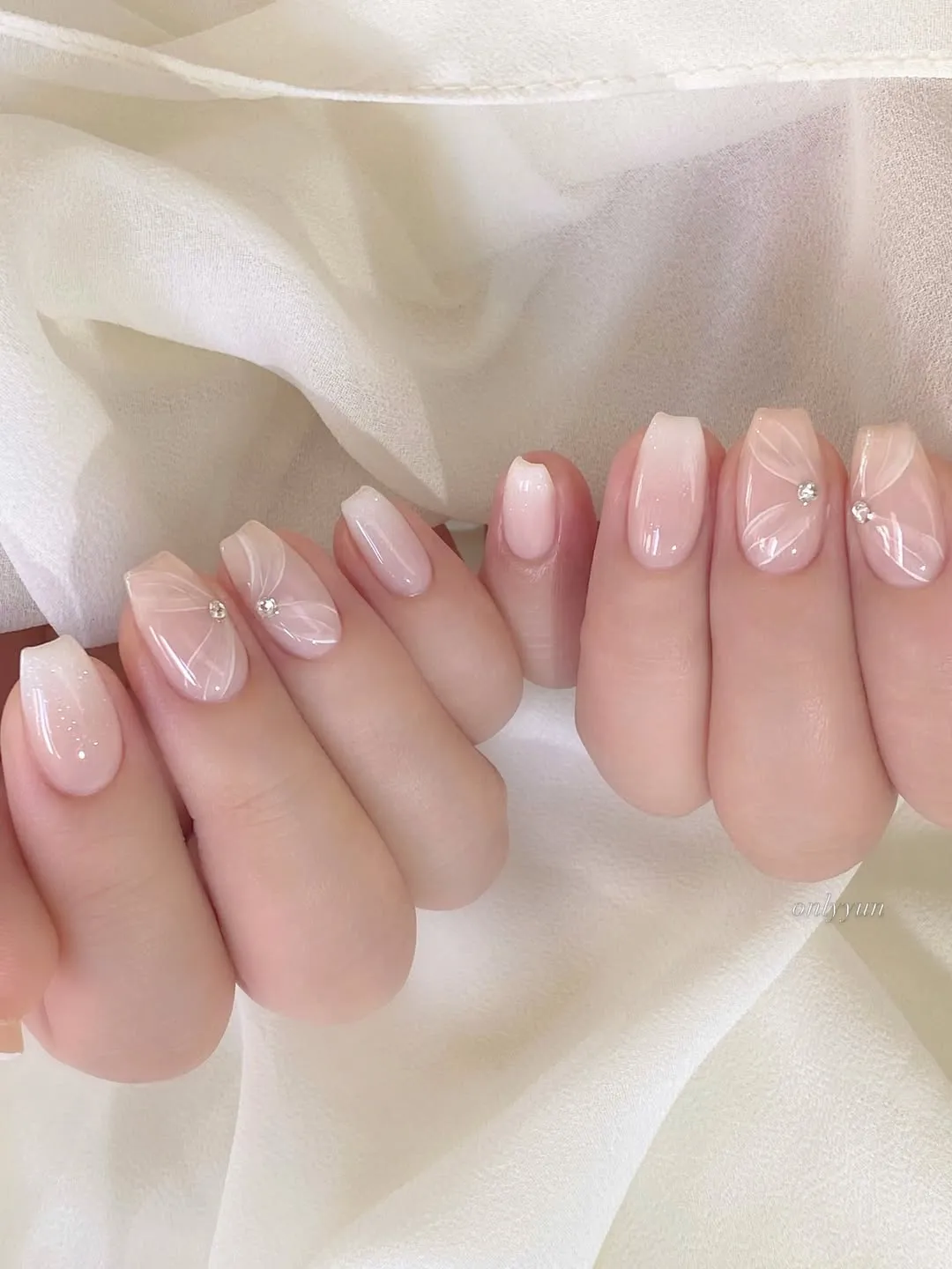 Soft pink-to-milky ombré squares with white leaf linework and rhinestones
