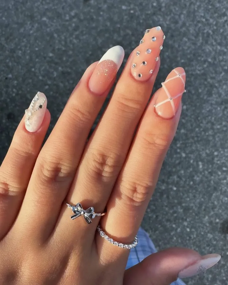 Nude long nails with glitter fade, rhinestones, and crisscross lines