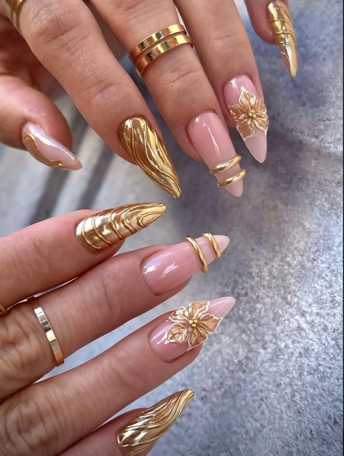 Sculpted gold statement nails mixed with nude-pink bases