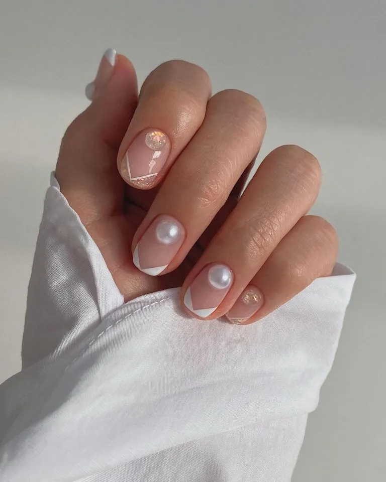 Short nude nails with white tips and pearl-like accents