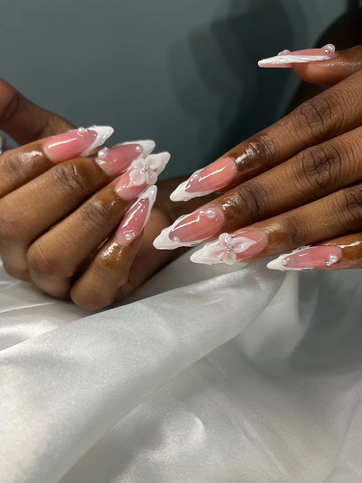Pink stilettos with sculpted white tips, pearls, and 3D flowers