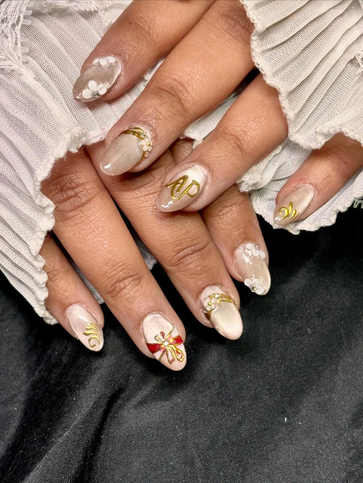 Beige shimmer with white flowers, gold motifs, and a red bow accent