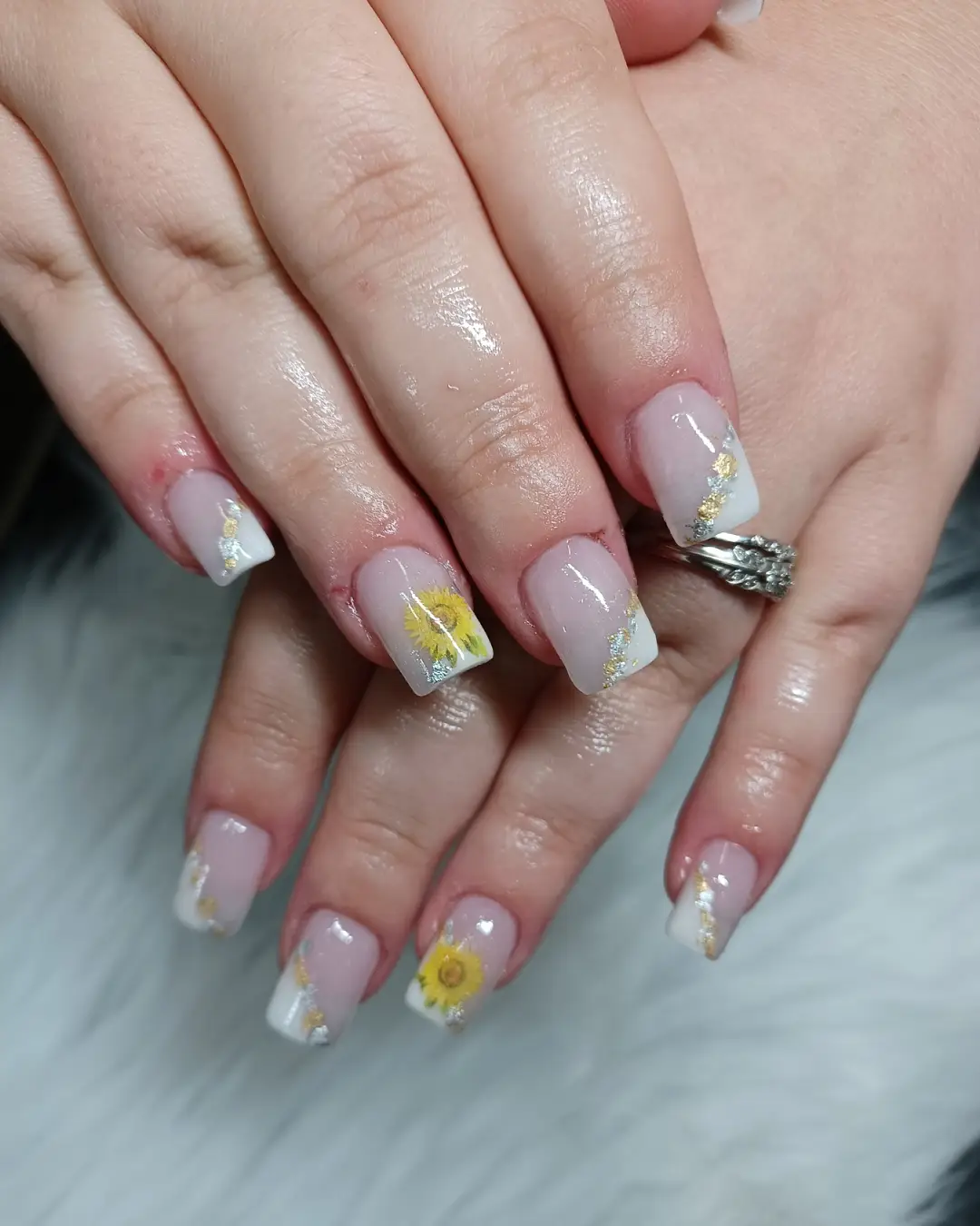 Pink square nails with white tips, gold/silver accents, and yellow flowers
