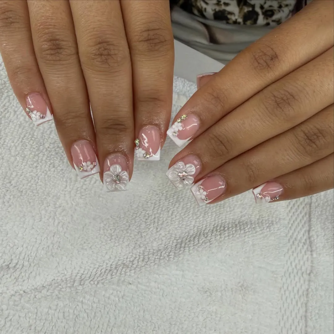 Pink French tips with raised white flower accents